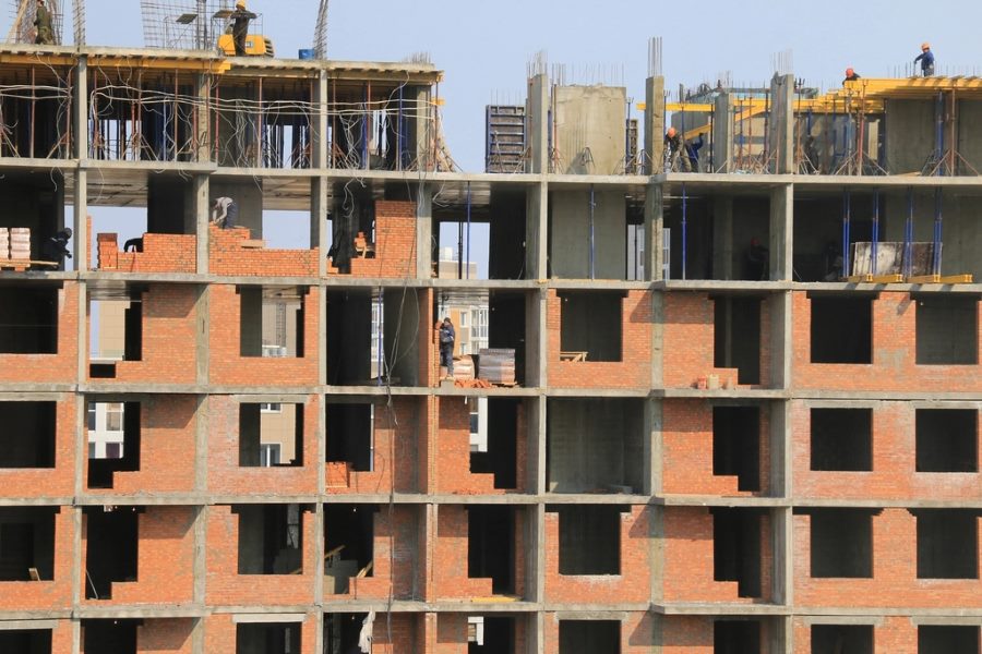 Construction worker treating an external brick wall surface of a residential building