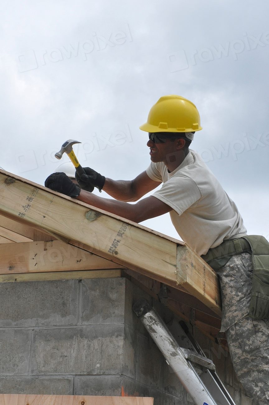 Workers preparing a flat rooftop surface before applying a waterproofing system